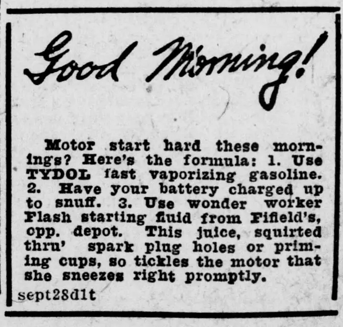 Advertisement in a ruled box with the handwritten-style headline "Good Morning!" above a block of text about hard motor starting, listing a gasoline brand, battery charging, and a starting fluid sold at a shop opposite the depot, with a small date code at the lower left.