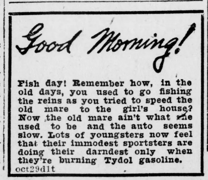 Boxed newspaper advertisement with a large handwritten-style greeting at the top and a paragraph of text below comparing driving an old mare to driving a car, ending with a mention of a brand of gasoline, with a small dated code line in the lower left corner.
